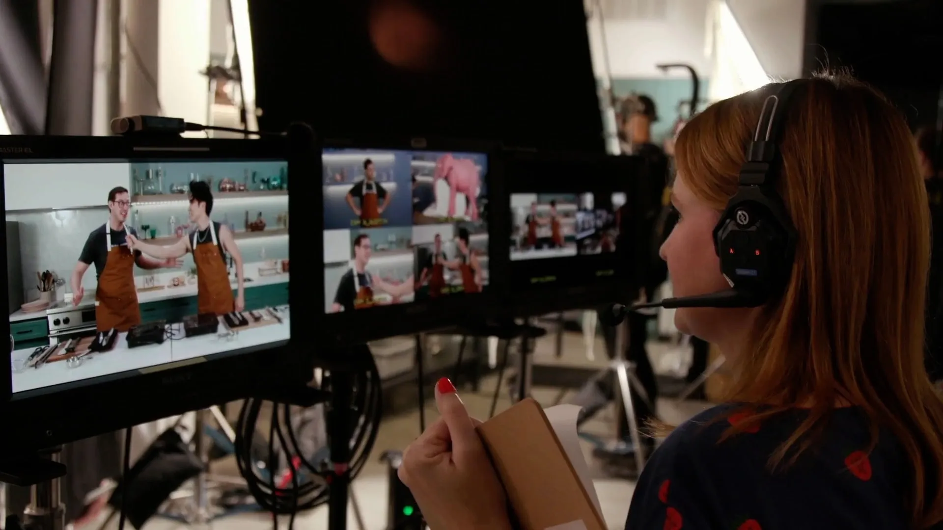 a woman with headphones on looking at a television screen